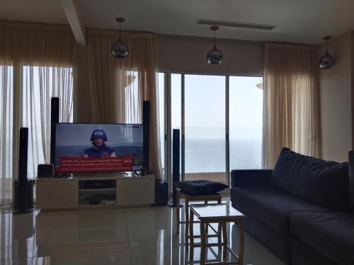 ديار البحر في جدة: غرفة معيشة مع تلفزيون وأريكة زرقاء