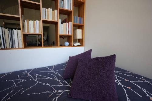 een slaapkamer met een paarse bank en boekenplanken bij LOFT entero con excelente ubicación, a minutos de AGUADA PARK in Montevideo