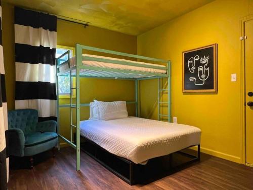 Blue Bungalow near OU Med/Downtown في مدينة اوكلاهوما: غرفة نوم مع سرير بطابقين وكرسي