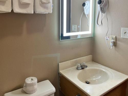 W łazience znajduje się umywalka, lustro i toaleta. w obiekcie Motel 6 Litchfield, IL w mieście Litchfield