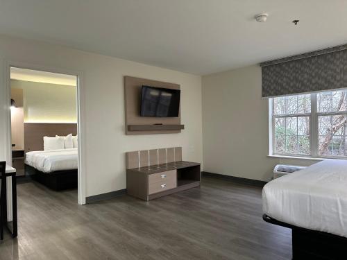 a hotel room with two beds and a flat screen tv at MainStay Suites Columbia Harbison in Columbia