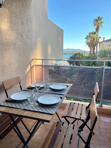 une table avec des assiettes et des verres sur un balcon dans l'établissement Tout proche de la plage, à 12 min à pied du port, place de parking, à Bandol