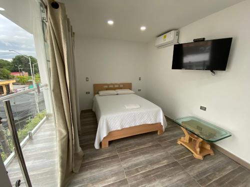 a bedroom with a bed and a flat screen tv at Hotel Dubai Deluxe Curumani in Curumaní