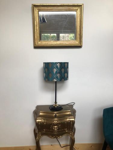 a lamp on a table in a room with a mirror at Dépendance de charme - Tiny house in Colmar