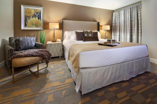 a bedroom with a large bed and a chair at Holiday Inn Club Vacations at Desert Club Resorts in Las Vegas