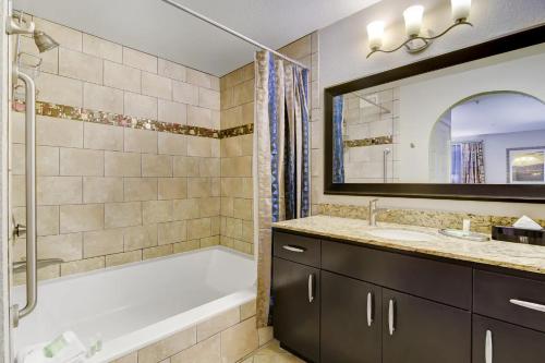 a bathroom with a tub and a sink and a mirror at Holiday Inn Club Vacations at Desert Club Resorts in Las Vegas