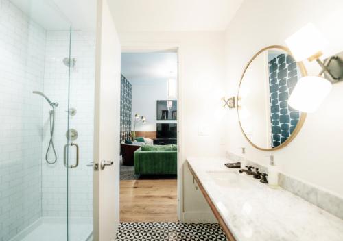 Un baño con ducha, lavabo y espejo. en Reunion Hotel, en Nashville