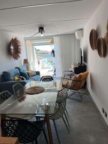 un salon avec une table en verre et des chaises dans l'établissement Bel appartement pieds dans l’eau, à Sète