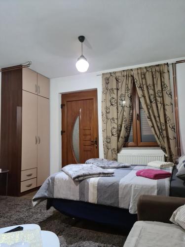 a bedroom with a bed and a window at Studio Apartman Ana Doboj in Doboj