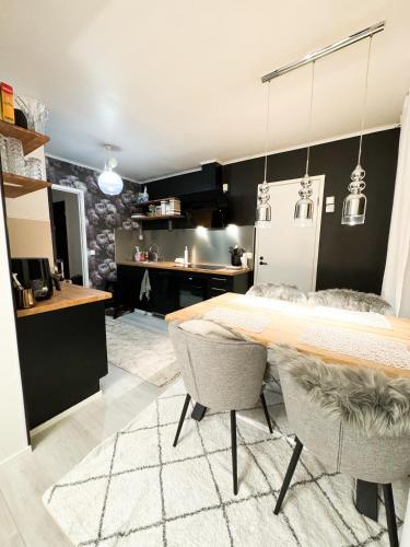 a kitchen with a table and two chairs and a refrigerator at Rubin Apartment - moderni huoneisto lähellä keskustaa in Kajaani