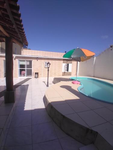 una piscina con sombrilla y sombrilla en Casa com piscina Laranjal, en Pelotas
