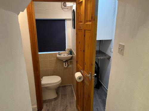 a small bathroom with a toilet and a sink at Sweet Cottage in Ingleton