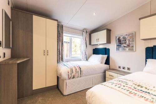 um quarto com 2 camas e uma janela em Woodland Jewel Lodge with Hot Tub em York