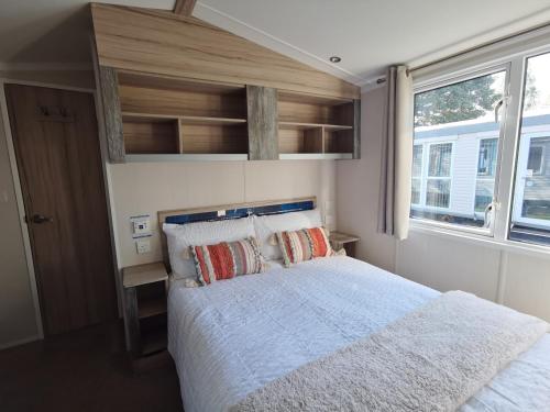 a bedroom with a large bed and a window at 8Berth- SmartTV- CloseToBeach- FamilyFriendly in Mablethorpe