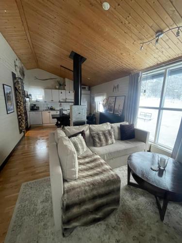 uma sala de estar com um sofá branco e uma mesa em Fjällstuga Huså em Åre