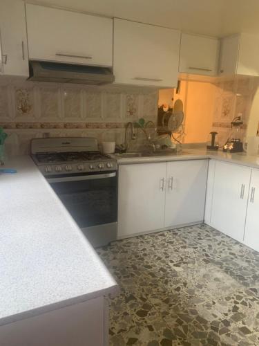 a kitchen with white cabinets and a stove top oven at Freddy's Suite in Ciudad Nezahualcóyotl