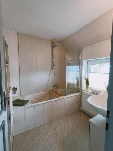a white bathroom with a tub and a sink at Haus Tourneur in Lippetal