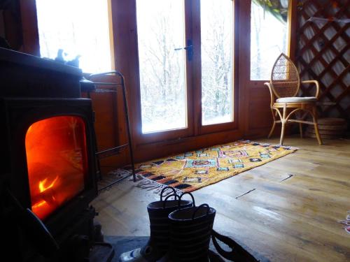 a living room with a fireplace and a rug at Wilding Yurt Stay in Broughton in Furness
