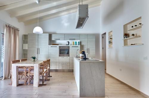 a kitchen with a table and a dining room at Beach Villa by Bobbywashere in Santa Maria