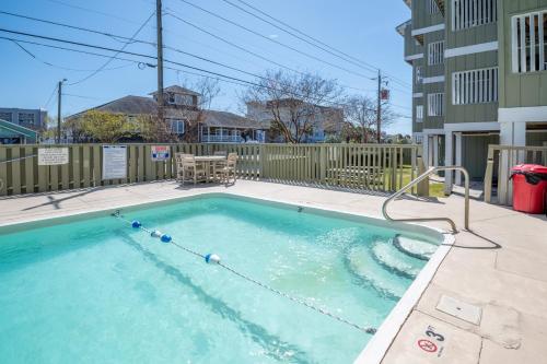 a small swimming pool in a yard next to a building at Condo in the heart of Downtown Carolina Beach in Carolina Beach