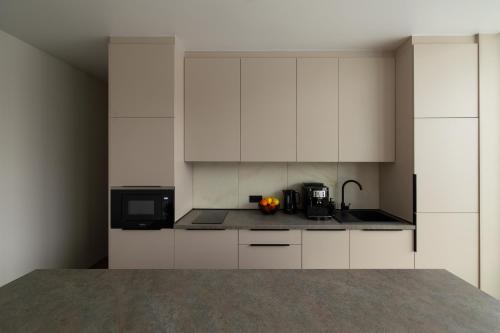 a kitchen with white cabinets and a microwave at PROSTIR in Korostov