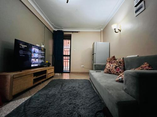 a living room with a couch and a flat screen tv at Kampala Flat in Kampala