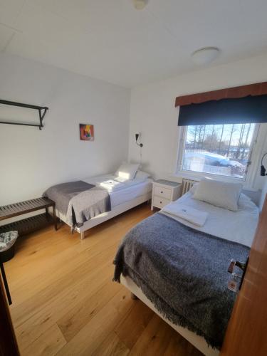 a bedroom with two beds and a window at Sp&oacute;i Guesthouse in Hvolsv&ouml;llur