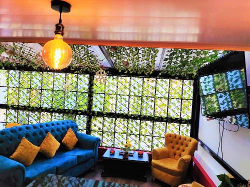 a living room with a blue couch and a chair at Hotel Kristal Ferial in Bogotá