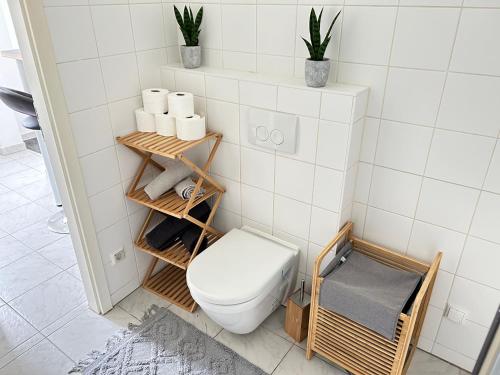 bagno con servizi igienici, asciugamani e piante di Charming Apartment a Vienna