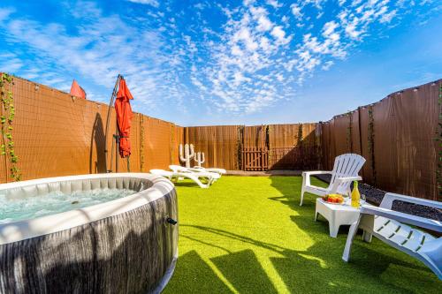 a backyard with a hot tub and chairs and a fence at Villa Colibri Dorado in Lajares