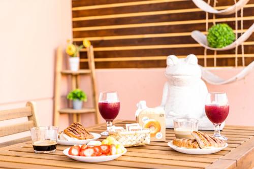 una mesa de madera con platos de comida y copas de vino en Villa Colibri Dorado en Lajares