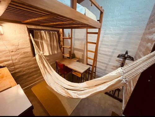 a hammock in a room with a table and a bed at Yê Tiny Houses in Palmeiras
