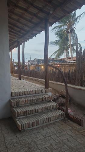 un conjunto de escaleras con una valla y una palmera en Casa Monã, en Maceió