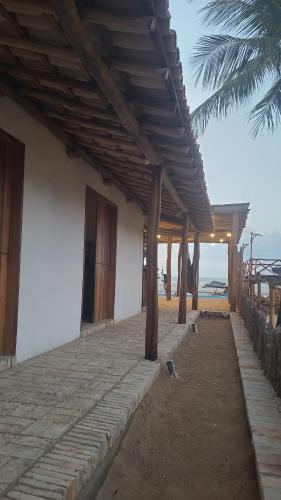un edificio con techo de madera en la playa en Casa Monã en Maceio