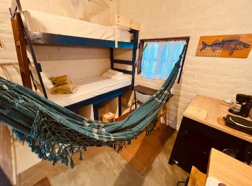 a hammock in a room with a desk at Yê Tiny Houses in Palmeiras