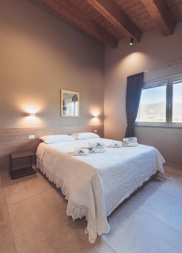 a bedroom with a large white bed with a window at Agriturismo Querceto in Frazione Mocaiana