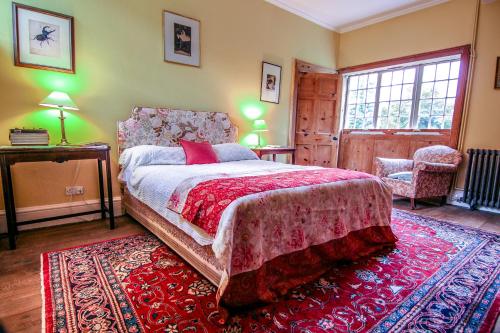 Un dormitorio con una cama grande y una alfombra roja en Garden House, en North Lydbury