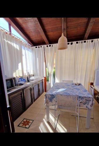 a kitchen with a table in the middle of a room at Casa Poseidon San Teodoro in San Teodoro