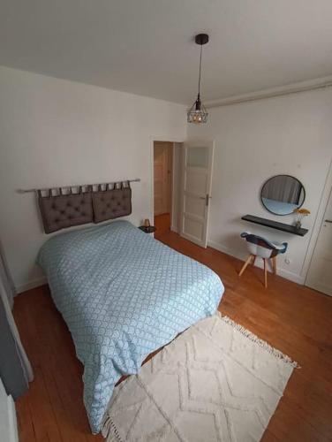 Schlafzimmer mit einem Bett mit blauer Decke in der Unterkunft Le Blue IVY 2 chambres Tout equipé Netflix in Le Creusot