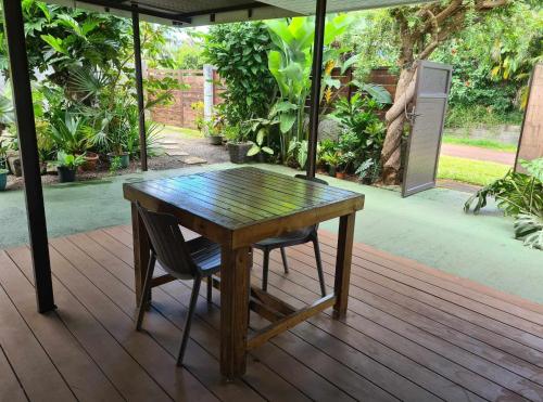 a wooden table and a chair sitting on a deck at Fare Miti-Rapa in Tohautu