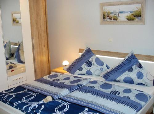 a bedroom with a bed with blue and white pillows at Ferienhaus Lachmöwe in Fehmarn