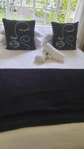 a bed with a cast on it with pillows at Secret Guest House in Pietermaritzburg