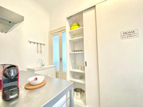 eine Küche mit einem Kühlschrank und einer Schale auf einer Theke in der Unterkunft [Porta-Venezia/Milano Centrale]Luxury Apartment in Mailand