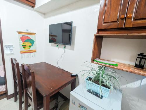 een keuken met een houten tafel en een kleine tafel met een plant bij Skies Condo unit in Moldex Residences Baguio in Baguio