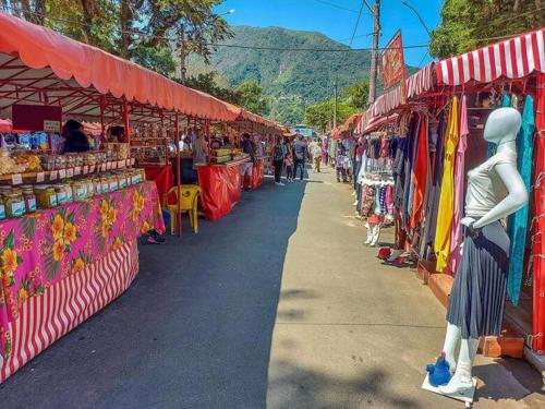 a group of stalls in a market with people walking around at Loft Moderno e Charmoso em Teresópolis - Alto in Teresópolis