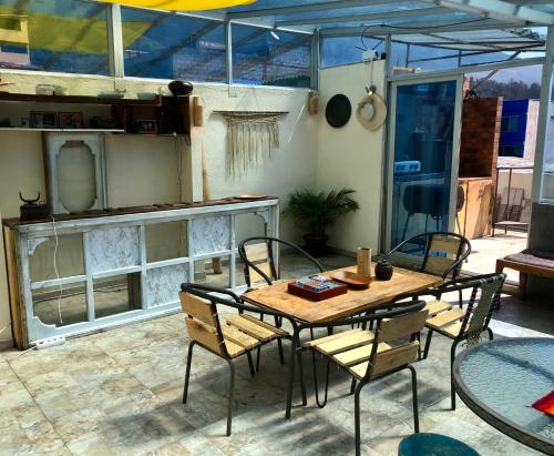 patio ze stołem i krzesłami na patio w obiekcie Llamingo Hostel w mieście Quito