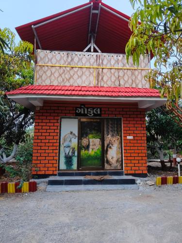 a small red brick building with animals in the window at Gokul farm house in Sasan Gir