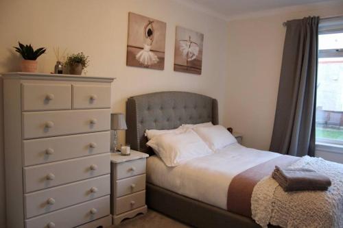 Cardonald的住宿－Amazing 2-Bed Home w/ Private Garden Free Parking，一间卧室配有一张床和一个梳妆台