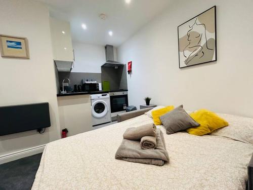 a bedroom with a large bed with yellow pillows at Cosy Studio near Emirates Stadium in London