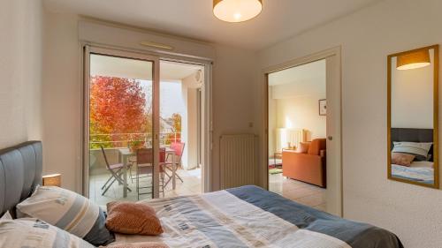 - une chambre avec un lit et un balcon dans l'établissement Appart cosy avec grand balcon et parking privatif, à Lorient